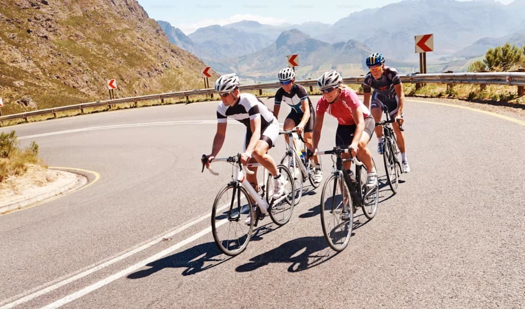Four cyclists riding together on a mountain road